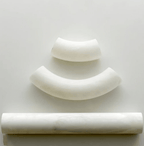 Clérachic Vista alabaster components arranged on white — two curved segments above one straight polished bar.