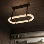 Clérachic Vista seen from beneath, the alabaster ring bright against dark wood with straps set into a bronze plate.
