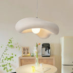 Textured white Clérachic pendant in a bright kitchen corner, with a cream fridge, a rattan cabinet and green branches nearby.
