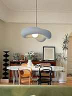 Grey Clérachic pendant above an oval white table with bentwood chairs, a dark sideboard and a potted plant behind.