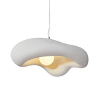 White Clérachic pendant with a rough-textured wavy shade on a plain white backdrop, its bulb glowing in the warm inner surface.