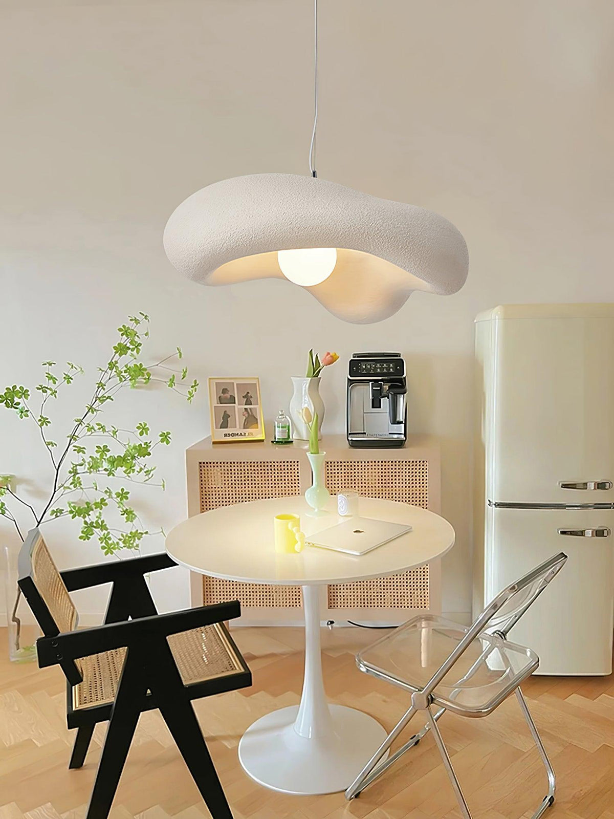 Beige Clérachic pendant above a small round table with a coffee machine, a cream fridge and a black wooden chair.