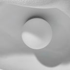Close view from below of the round white bulb under the textured shade of this Clérachic pendant.