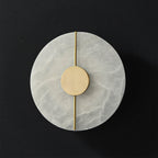 The Clérachic round alabaster wall lamp photographed unlit on black, its brass rod running the full width.