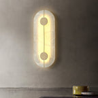 The Clérachic tall wall lamp glowing on a limewashed plaster wall above a counter set with ceramic bowls.