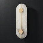 Clérachic tall alabaster wall lamp shown unlit, two brushed brass discs pinned along its slender rod.