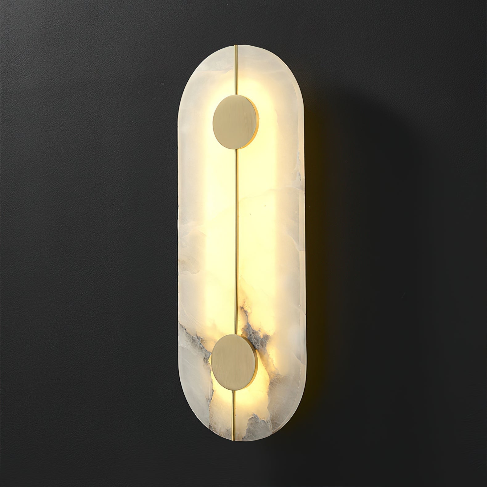 The Clérachic tall wall lamp lit against charcoal, the alabaster edge glowing warm around the brass rod.