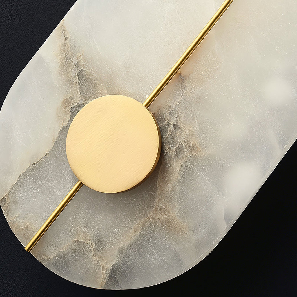 Clérachic wall lamp detail: a brass rod crossing the brass disc over deeply veined alabaster, seen up close.