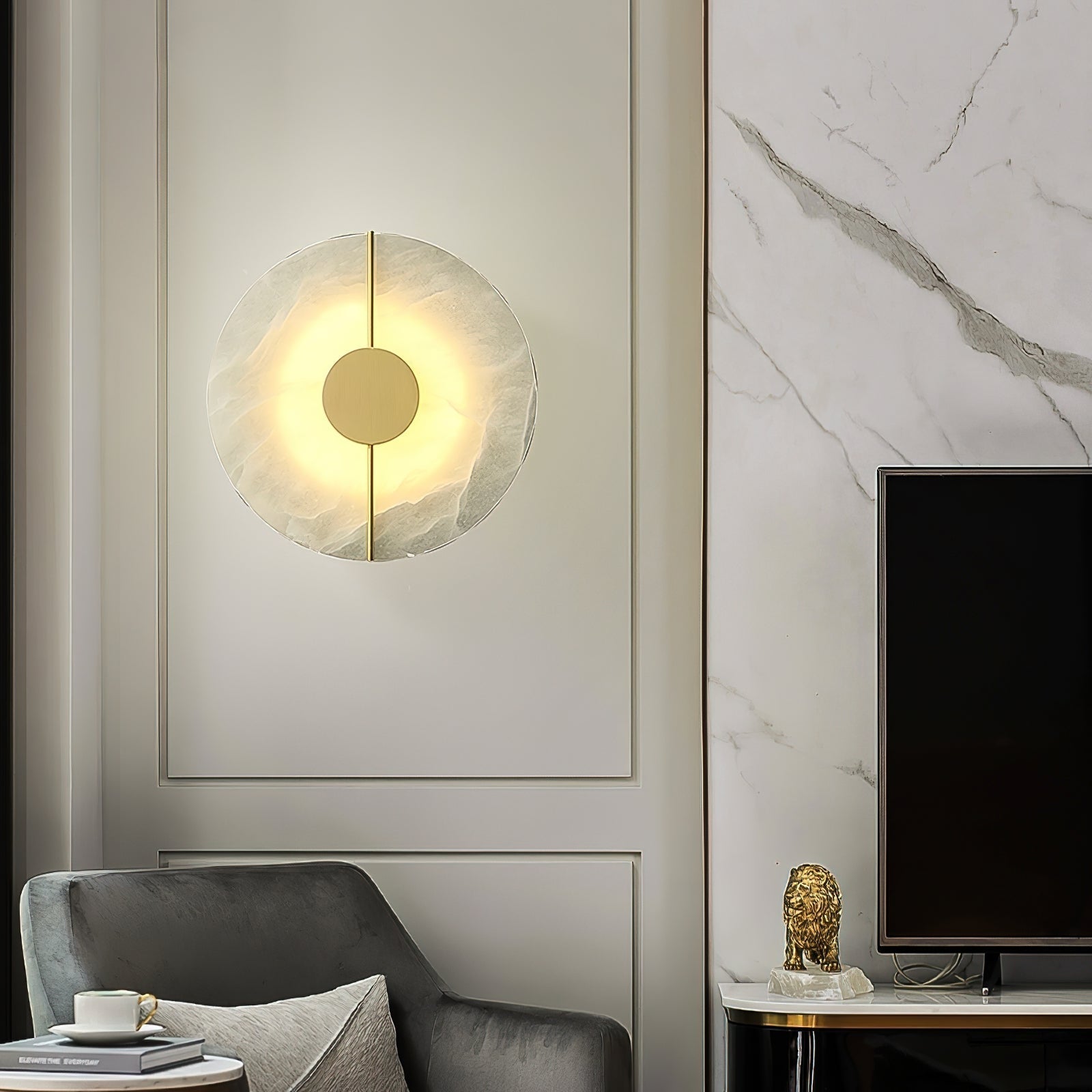 Clérachic round alabaster wall lamp lit on cream panelling beside a marble wall in a sitting room.