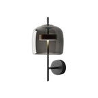 Black version of this Clérachic wall light, with a smoke grey glass shade, a black stem and a round black backplate, on white.