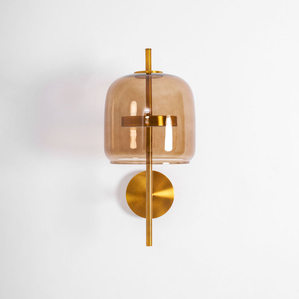 Front view of this Clérachic wall light, with a coffee glass shade, gold ring, gold stem and round backplate, unlit on white.