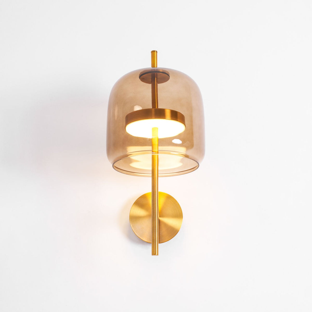 Slightly raised view of this Clérachic wall light, showing the lit gold ring and light disc inside the coffee glass shade.