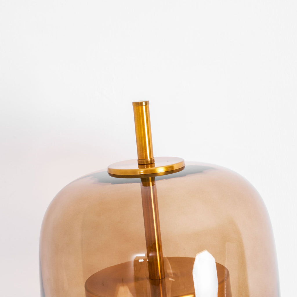 Close view of the top of the coffee glass shade, the gold cap and the stem of this Clérachic wall light.