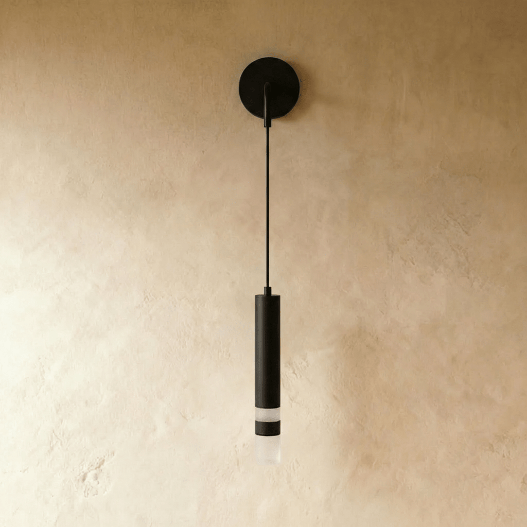 Clérachic matte black wall light on a round backplate, with a long cord and a slim cylinder ending in a frosted diffuser.