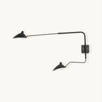 This Clérachic two-head wall light on a plain backdrop, with black curved arms ending in cone shades and brass joints, on a square wall plate.
