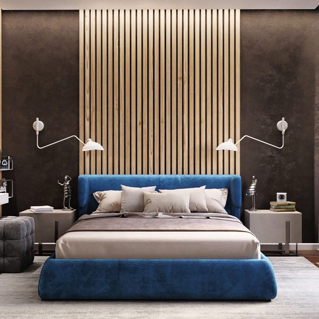 Pair of Clérachic wall lights with white cones and curved arms above a blue velvet bed, in front of a slatted wood panel.