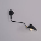 Clérachic black one-head wall light with a curved arm and a bare bulb, on a mauve-grey wall.