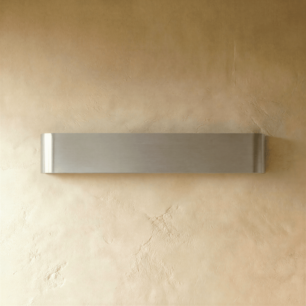 Clérachic long brushed silver aluminium wall light switched off, showing its fine horizontal grain on textured plaster.