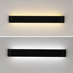 Clérachic long black aluminium wall light shown twice, lit in a warm white glow above and a cool white glow below.