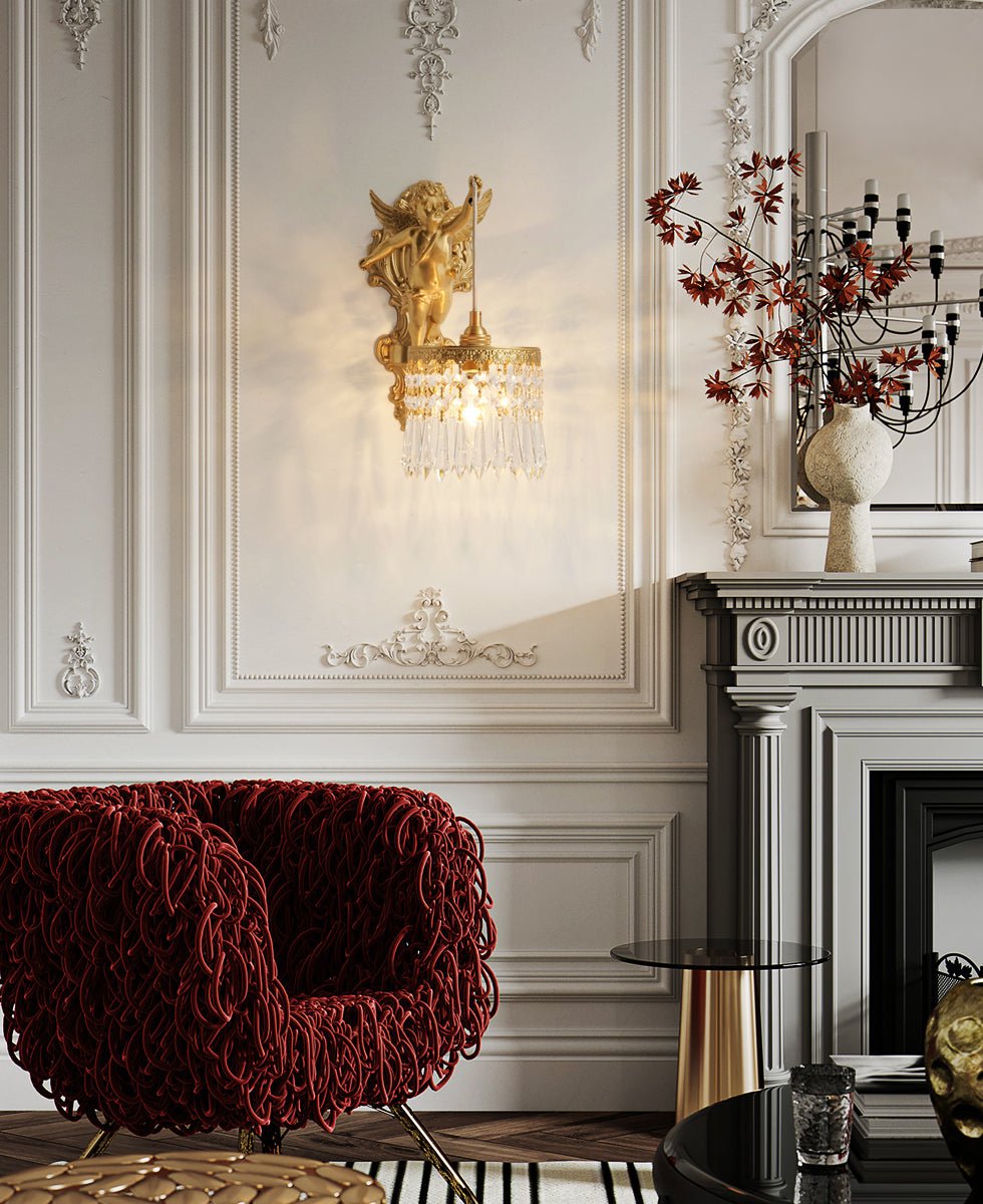 In a panelled white room with a red woven armchair and a grey fireplace, a Clérachic cherub wall light hangs above the seating.