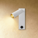 Clérachic white wall reading light with an angled cylinder head, gold-toned inner reflector lit warm and a black rocker switch.