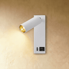 Clérachic white wall reading light lit warm, with a USB socket labelled on the lower backplate beside a small slot.