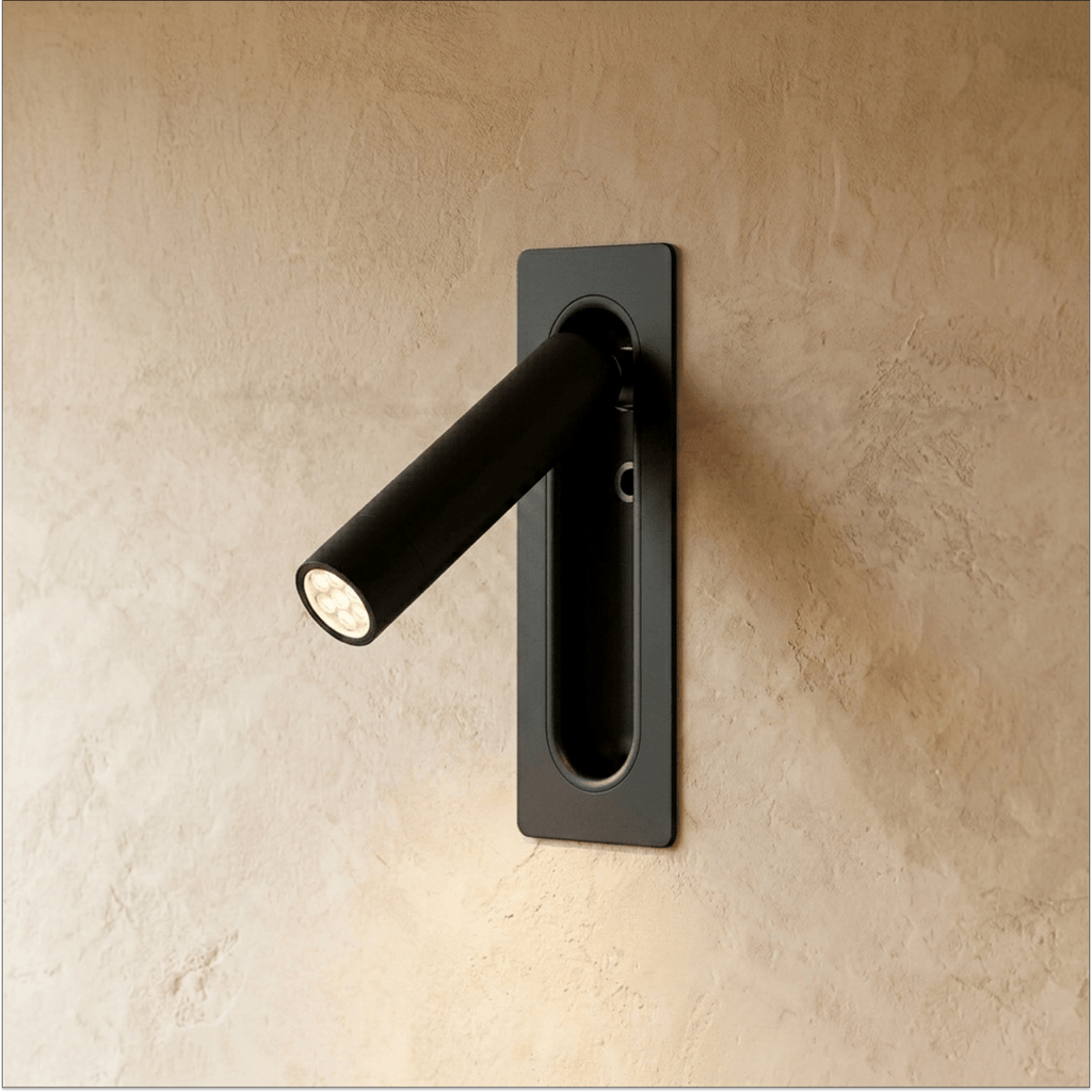 Clérachic slim wall-mounted reading light in matt black, its round-headed spotlight arm swung out from the plate.