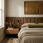 Clérachic wall reading lamp with a gold head on a black plate, mounted on a tan velvet headboard above a floating nightstand.