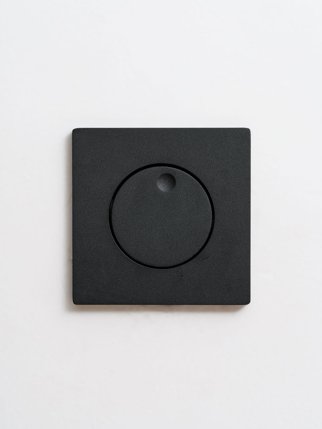 Front view of the closed black Clérachic recessed wall light, its round hood turned flat over the LED opening.