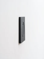 Side view of the slim black Clérachic recessed wall light, showing its flat square plate sitting close to the wall.
