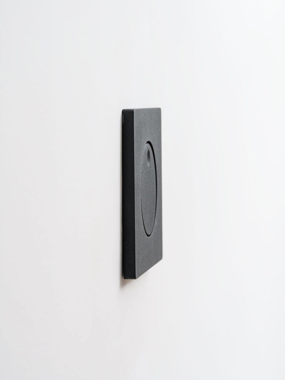 Side view of the slim black Clérachic recessed wall light, showing its flat square plate sitting close to the wall.