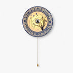 This Clérachic wall light on a white backdrop, a round blue and white porcelain shade with an orchid design and a brass bead pull chain.