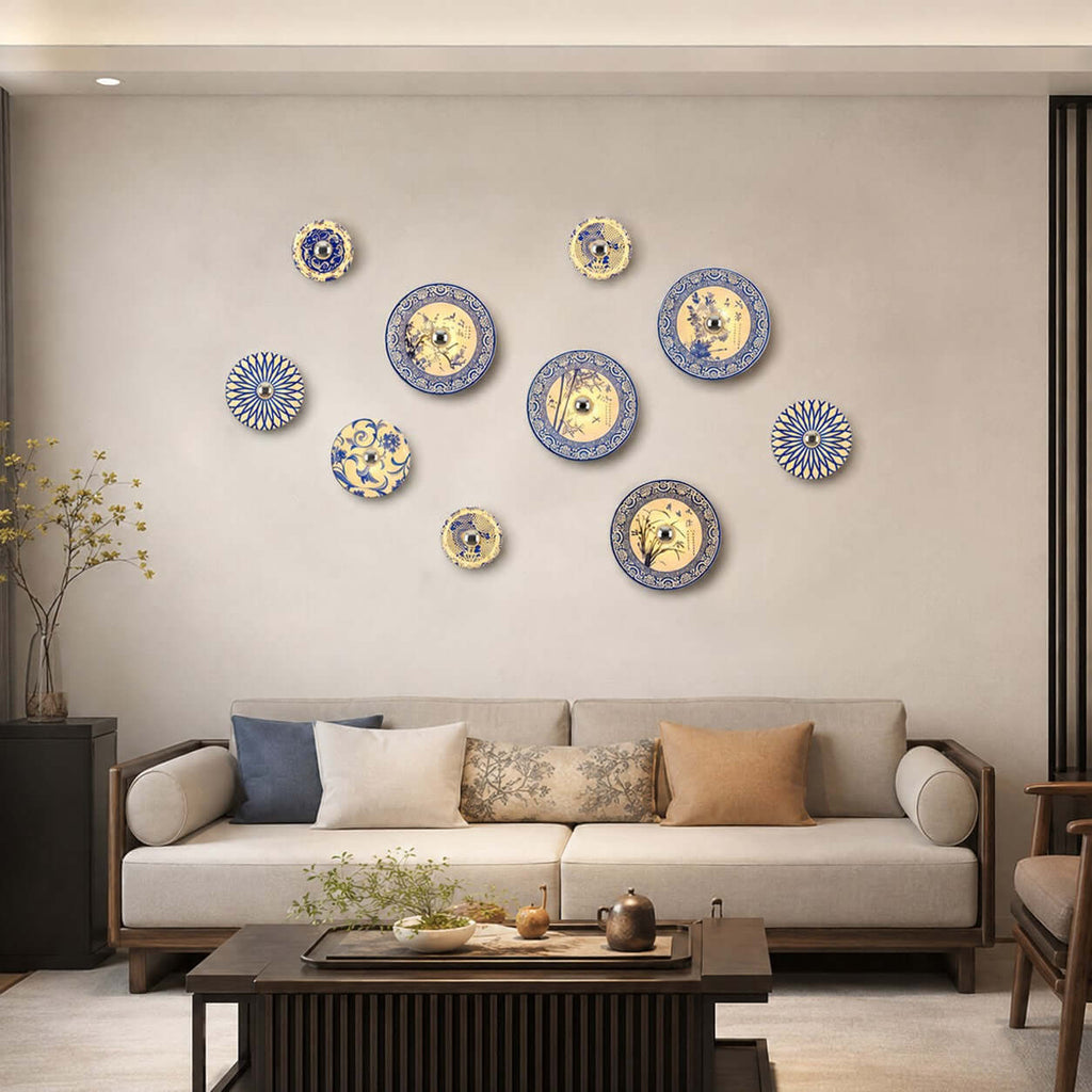 Clérachic wall lights in a loose cluster on a plain wall above a cream sofa, a low dark coffee table in front.