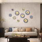 Clérachic wall lights in a loose cluster on a plain wall above a cream sofa, a low dark coffee table in front.