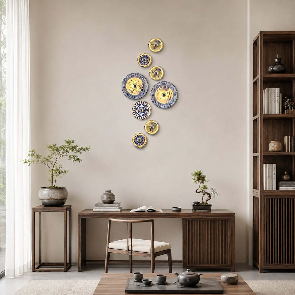 A vertical run of Clérachic wall lights in different sizes beside a tall bookshelf, above a writing desk with a tea tray.