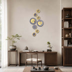A vertical run of Clérachic wall lights in different sizes beside a tall bookshelf, above a writing desk with a tea tray.