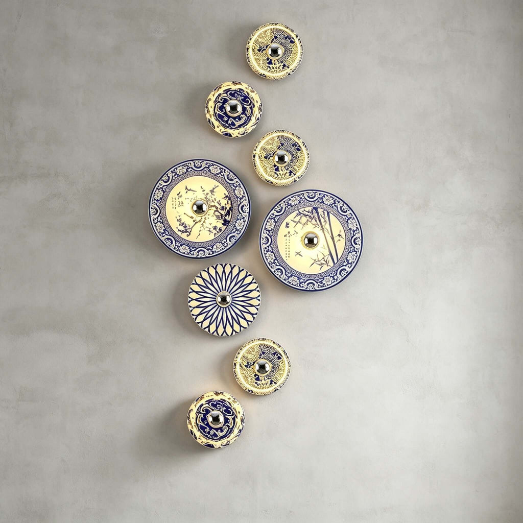 A tall vertical arrangement of Clérachic wall lights, large and small, on a concrete-grey wall.