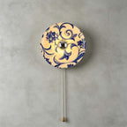 Clérachic wall light with a scrolling blue floral design on a cream shade and a brass chain with a teardrop pull.