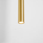 Underside of the brass tube with its LED lit, against a white wall, on this Clérachic wall light.