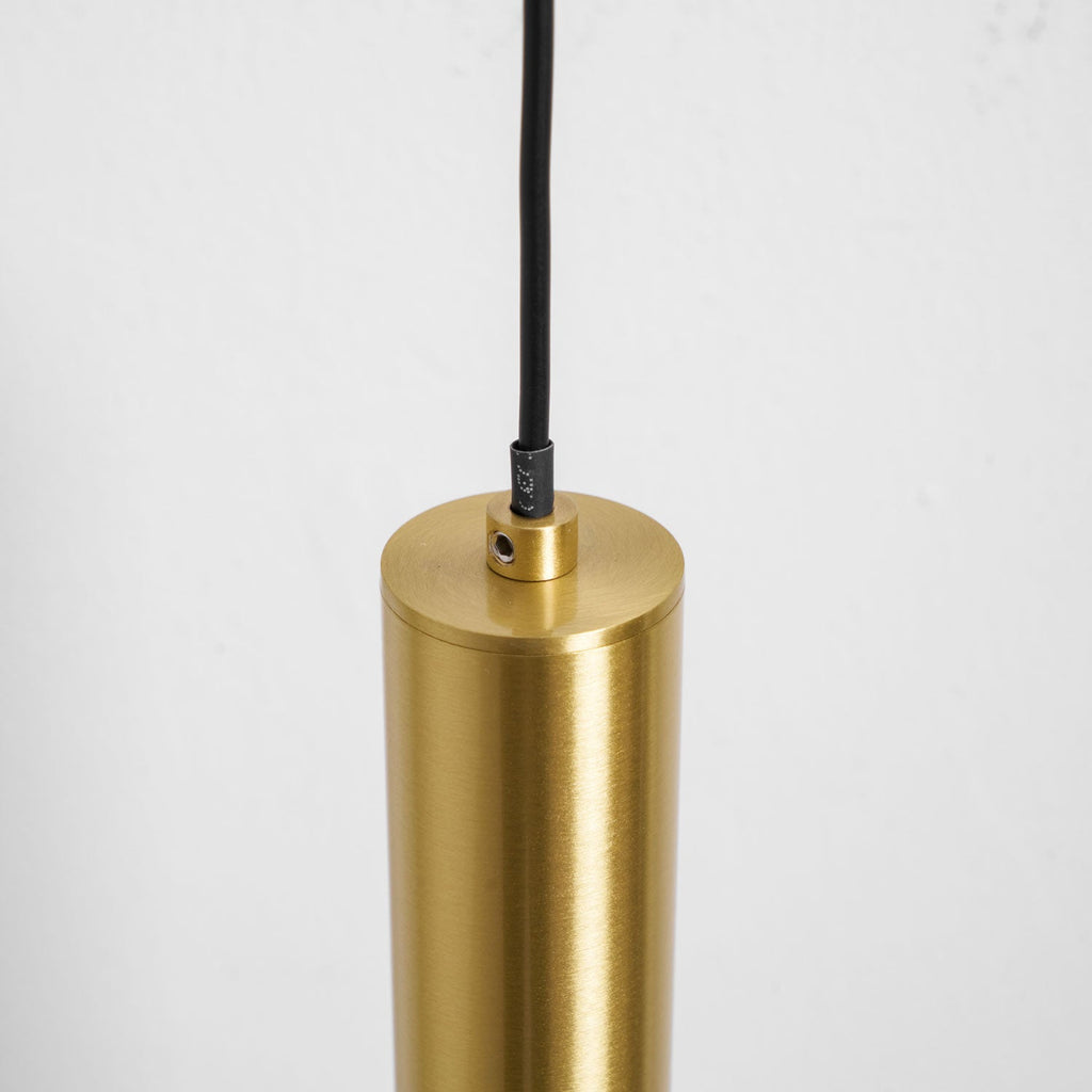 Close view of the top of the brass tube where the black cord enters, with a small fixing screw, on this Clérachic wall light.