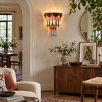 Hallway scene with a Clérachic wall sconce lit beside a round mirror, above a dark wood sideboard and a framed figure print.