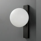 An unlit white globe sits against a dark metal bar on a charcoal wall, a side-on view of this Clérachic wall light.