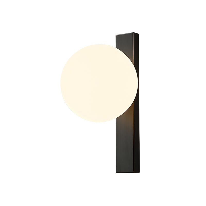 Cut-out of this Clérachic wall light on white, its warm lit globe overlapping the top of a tall black metal bar.