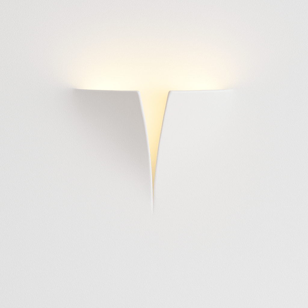 Clérachic white plaster-style wall light with curved surfaces meeting at a narrow V-shaped opening, washing light upward.