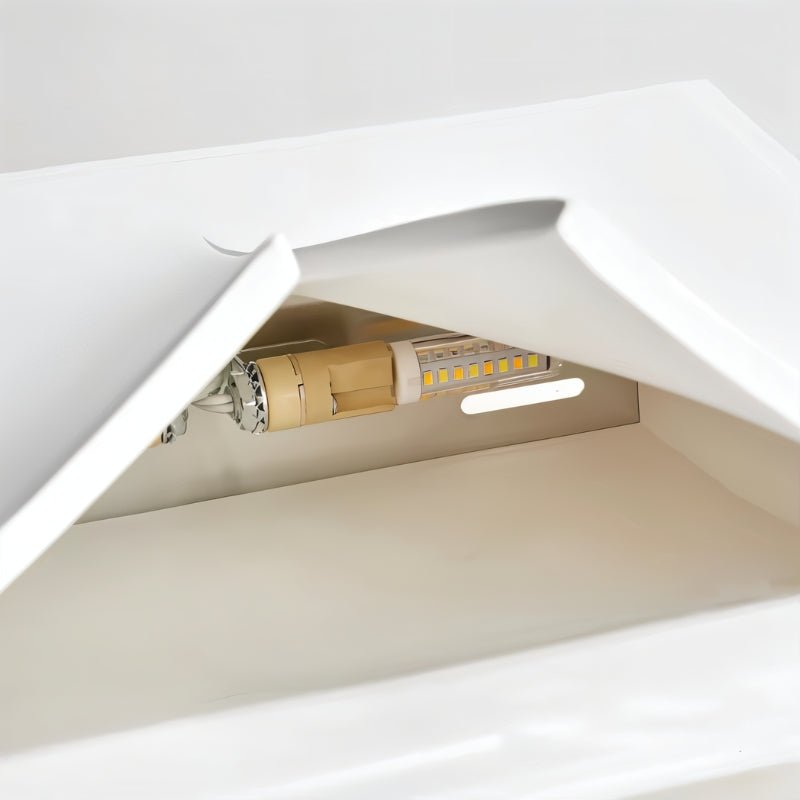 Close view inside a Clérachic white wall light, showing a warm-white LED bulb behind the curved plaster-style lip.