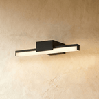 Clérachic slim black linear wall light with a square backplate, glowing warm against a textured limewash wall.