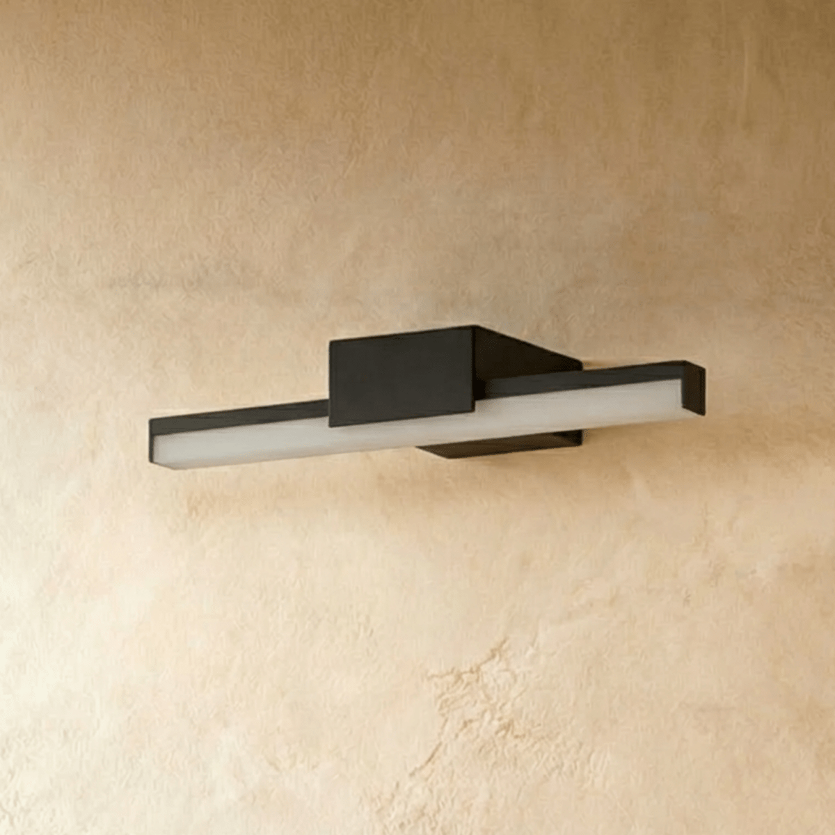 Clérachic short black linear bar wall light with a frosted diffuser, shown unlit on a warm plaster-effect wall.