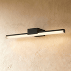 Clérachic long black linear wall light with a glowing frosted diffuser and a compact square backplate on plaster.