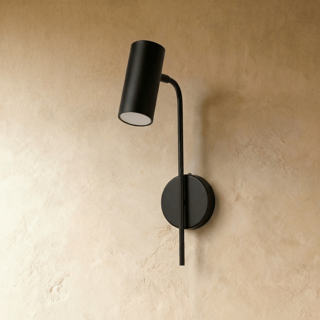 Clérachic black cylinder wall reading light switched off, on a slim curved arm from a round wall plate.