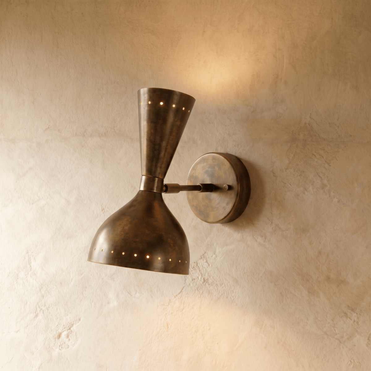 Clérachic wall lamp in vintage brass, an hourglass shade with perforated rims on a round wall plate.